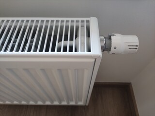 White radiator providing warmth and comfort in modern apartment set to level one