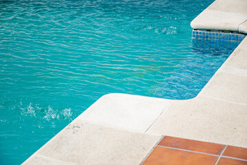 Fototapeta premium summer leisure inviting swimming pool corner with textured coping and calm water, summer background concept