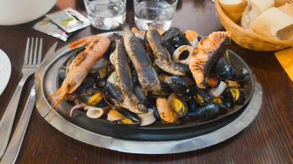 seafood plate with sardines shrimp mussels and fish in restaurant table