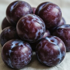 Obraz premium Closeup of a Pile of Ripe Purple Plums on a Light Background