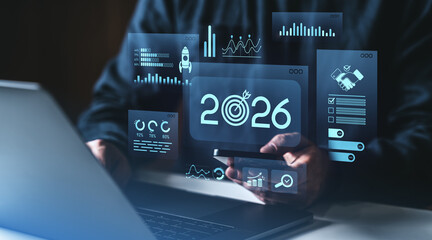 Businessman analyzing futuristic 2026 digital data dashboard on tablet screen.