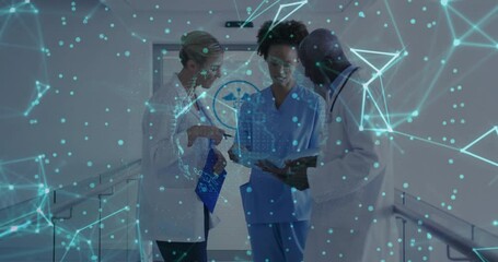 Nurse raising tablet initiating data overlay while doctors analyzing health data in corridor - Powered by Adobe
