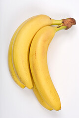 A top-down view captures a small bunch of ripe yellow bananas against a plain white background