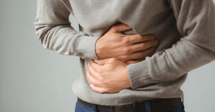 Man with stomach pain. Person holding stomach from discomfort. Suffering from abdominal pain or indigestion, seeking relief. Healthcare concern.