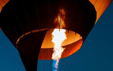 Massive gas burner inflating a hot air balloon creates an incredible scene against the backdrop of a twilight sky in Cappadocia, Turkey. Lighting the flame of a large balloon in the dark. Turkish trip