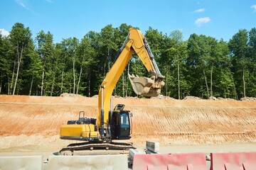 An excavator at a construction site performs construction work