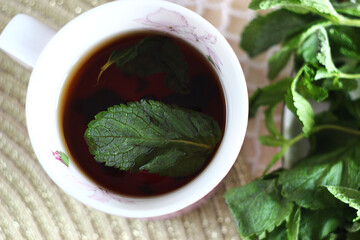 Black tea with mint in a mug on the table