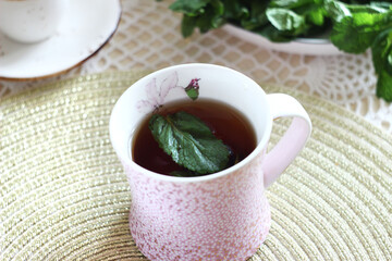 Black tea with mint in a mug on the table