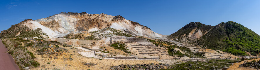 Panorama shot of blue sky and active volcano Mt.Esan with spewing smoke in Hakodate Hokkaido, Japan