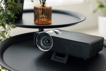 Modern video projector on black table indoors, closeup