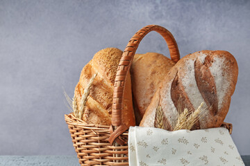 Many bread loaves and spikes in basket on table, closeup. Space for text