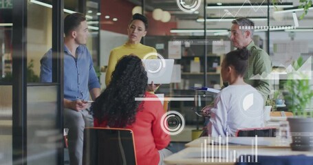 Presenter speaking causing semi-transparent graphs animating around team, laptop for business recap - Powered by Adobe