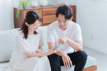 スマホを見る妊婦の妻と夫