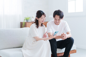 スマホを見る妊婦の妻と夫