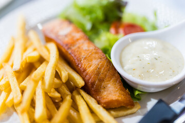 Tasty delicious grilled salmon steak served together with vegetable, french fries and dipping sauce