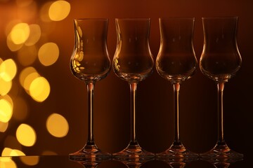 Many clean glasses on glass mirror surface against blurred lights. Bokeh effect