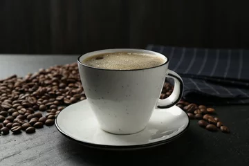 Fototapete Rund Aromatic coffee in cup and beans on black table, closeup © New Africa