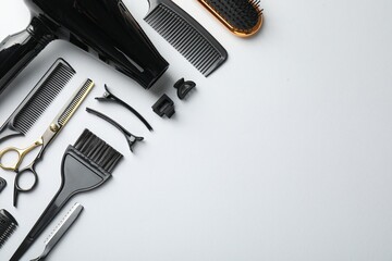 Different hairdresser's tools on white background, flat lay. Space for text