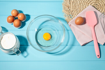 Making whipped cream. Bowl and ingredients on light blue wooden table, flat lay