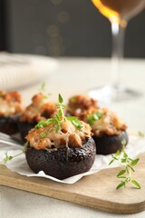 Tasty stuffed mushrooms served on light table against blurred background, closeup