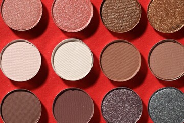 Beautiful eyeshadow refill pans on red background, flat lay