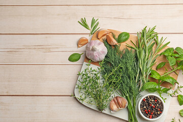 Different fresh herbs and spices on white wooden table, flat lay. Space for text