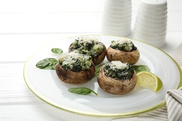 Tasty stuffed mushrooms served on white wooden table, closeup