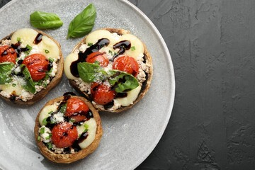 Tasty stuffed mushrooms served on black table, top view. Space for text