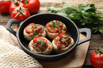Tasty stuffed mushrooms served on wooden table, closeup