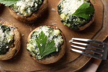 Tasty stuffed mushrooms served on wooden table, top view
