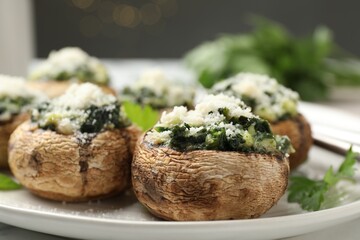 Tasty stuffed mushrooms served on white table against blurred background, closeup