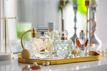 Bottles of different perfumes on white table indoors, closeup