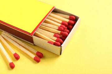 Matches in box on yellow background, closeup