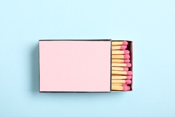 Matches in box on light blue background, top view. Mockup for design