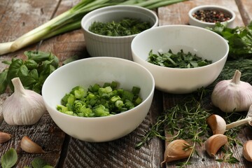 Different fresh herbs and spices on wooden table, closeup