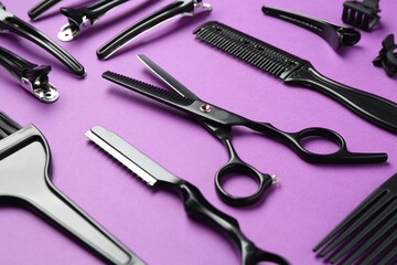 Different hairdresser's tools on violet background, closeup