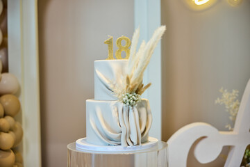 Beautiful two-tier cake decorated with pampas grass for an 18th birthday celebration at a stylish event venue