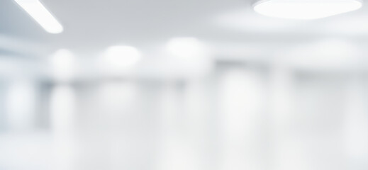 Blurred abstract background of a bright white interior space with lights.