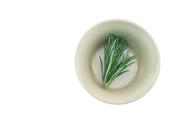 ciotola mortaio in ceramica verde con rametti di rosmarino fresco su sfondo bianco o trasparente, vista da sopra