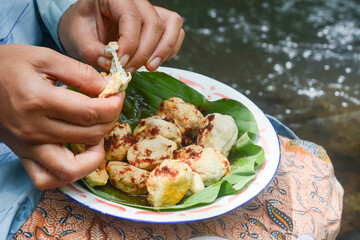 Close up of a woman eating basreng and typical Indonesian nyemek noodles