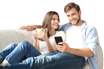 Young couple watching online content in a smart phone sitting on a sofa on a transparent background