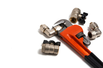 Adjustable pipe wrench and plumbing fittings isolated on white background.