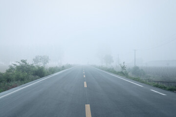 A foggy road stretching into the distance under a misty sky