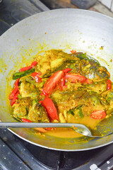 Fish curry that is being cooked using thick and spicy coconut milk