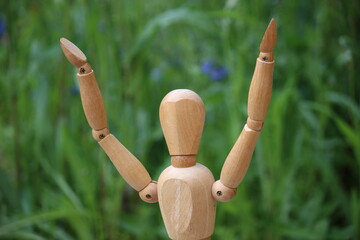 Wooden man with arms held high