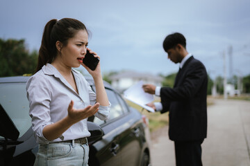 Fototapeta premium Asian woman talking on the phone asking for help in claiming insurance in case of an accident