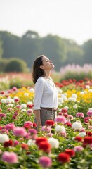 Woman enjoying the sunlight in a vibrant flower field, eyes closed.