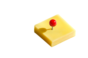 A minimalistic studio shot featuring cheese and a red pin against a black backdrop