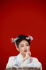 Girl wearing Chinese Ming Dynasty Hanfu costume against a red background