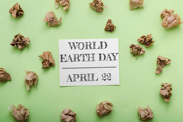 Green background with a piece of paper that says World Earth Day on it
